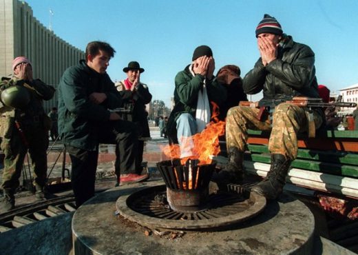 Combattants tchétchènes (partisans du président Doudaev) priant en face du Palais présidentiel à Grozny, Wikimédia, 1994, CC-BY-3.0.